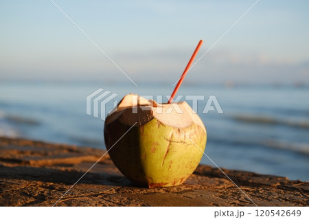 Coconut with straw on the beach. Selective focus. Coconut with straw on the beach. Selective focus. 120542649