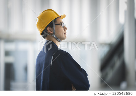 ヘルメットを被った作業服姿の40代の男性 横顔 ヘルメットを被った作業服姿の40代の男性 横顔 120542680