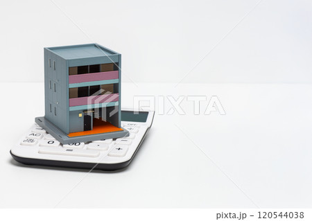 電卓と戸建て住宅の模型でローンのイメージ 120544038