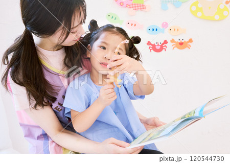 園児と絵本を読む保育士 120544730