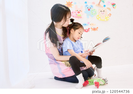 園児と絵本を読む保育士 120544736