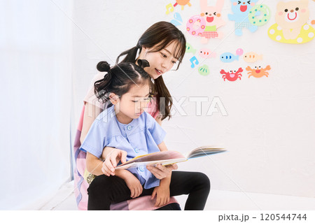 園児と絵本を読む保育士 120544744