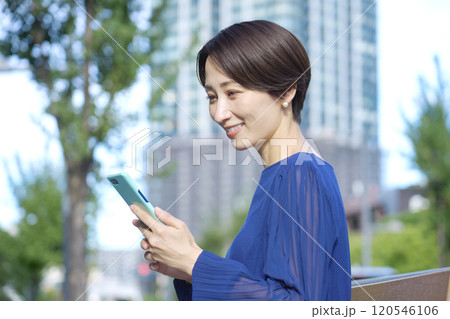 スマホを操作する女性　40代　オフィス街 120546106