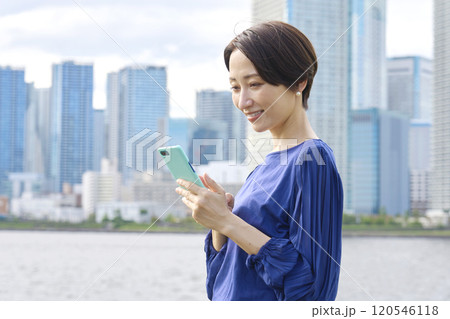屋外でスマホを操作する女性 120546118