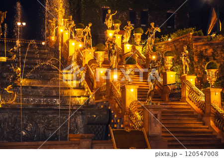 Fountain with cascades decorated with statues illuminated at night Fountain with cascades decorated with statues illuminated at night 120547008