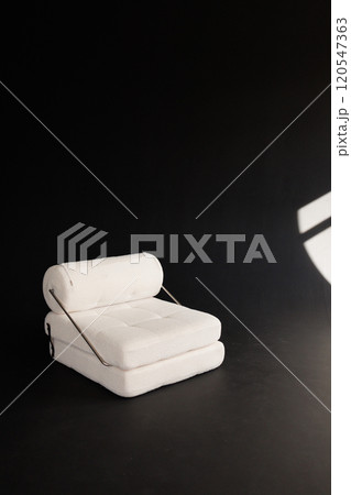 A white modern chair with a black background A white modern chair with a black background 120547363