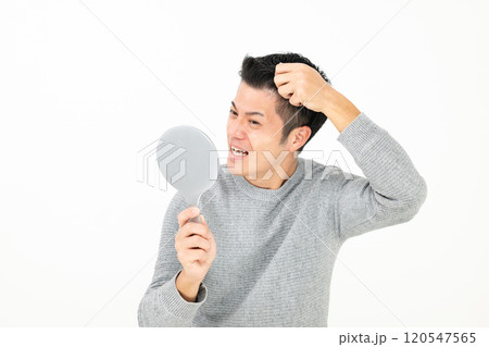 鏡を見て髪を気にする男性 120547565