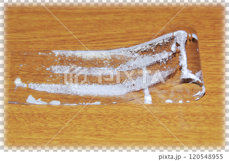 薄膜從酥餅上剝下來，折疊起來，放在木紋桌上，裡面黏著白色的奶油。 120548955