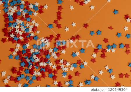 red white and blue sugar candies for decoration on an orange background 120549304