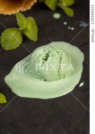 green ice cream with mint flavor on a black slate surface 120549321