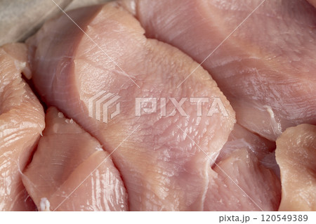 a lot of a piece of fresh chicken meat in close-up lies on paper a lot of a piece of fresh chicken meat in close-up lies on paper 120549389