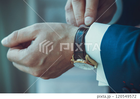 Businessman looking at his watch punctuality.A man puts a watch on his hand. Businessman looking at his watch punctuality.A man puts a watch on his hand. 120549572