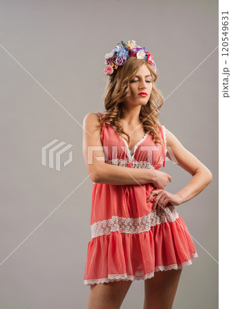 Charming girl.The woman is dressed in a pink dress. A wreath of flowers on her head. 120549631