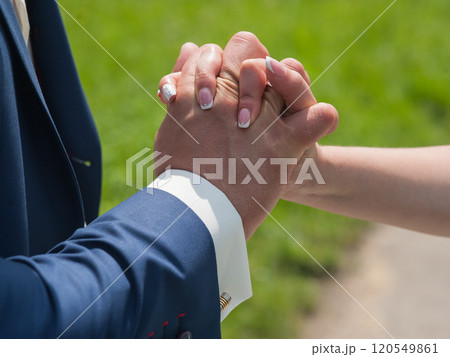 Couple holding hands outdoors feeling.hands close up of a couple in love Couple holding hands outdoors feeling.hands close up of a couple in love 120549861