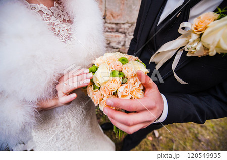 A young couple with a bouquet of yellow roses wedding.Bride holding wedding bouquet, wedding dress, wedding details A young couple with a bouquet of yellow roses wedding.Bride holding wedding bouquet, wedding dress, wedding details 120549935