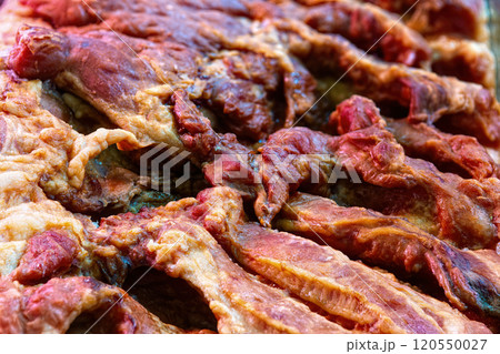 Pork dried meat jerky close-up background, top view. 120550027