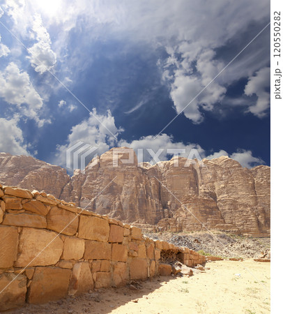 Mountains of Wadi Rum Desert also known as The Valley of the Moon is a valley cut into the sandstone and granite rock in southern Jordan 60 km to the east of Aqaba Mountains of Wadi Rum Desert also known as The Valley of the Moon is a valley cut into the sandstone and granite rock in southern Jordan 60 km to the east of Aqaba 120550282