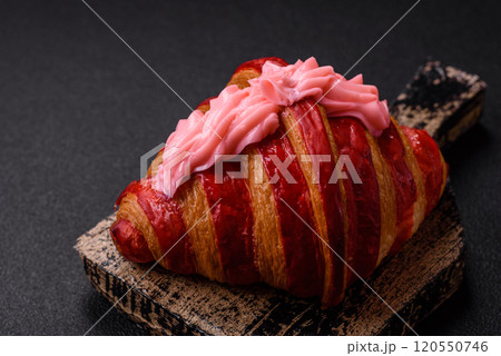 Crispy fresh red croissant with cream and strawberries 120550746