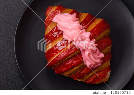 Crispy fresh red croissant with cream and strawberries 120550759