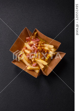 Crispy French fries with pieces of bacon, salt and spices Crispy French fries with pieces of bacon, salt and spices 120551495