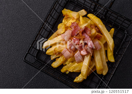 Crispy French fries with pieces of bacon, salt and spices 120551517