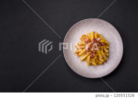 Crispy French fries with pieces of bacon, salt and spices 120551526