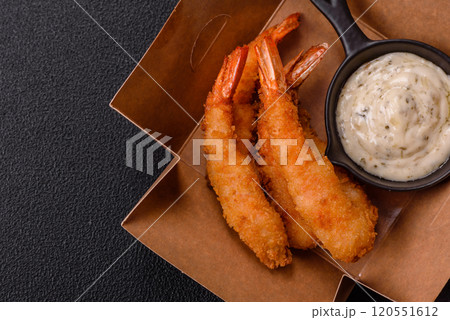Hot crispy shrimp breaded with salt and spices with white sauce 120551612