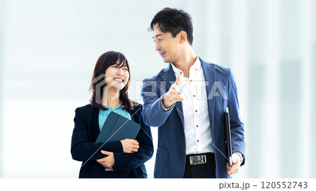 オフィスを並んで歩く男女2人の日本人ビジネスマン 120552743