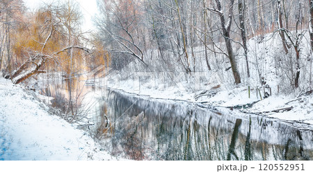 Fabulous landscape in city park with snowy trees and beautiful frozen river. Fabulous landscape in city park with snowy trees and beautiful frozen river. 120552951