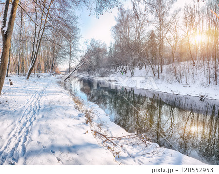 Fabulous landscape in city park with snowy trees and beautiful frozen river. Fabulous landscape in city park with snowy trees and beautiful frozen river. 120552953