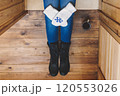 A girl in the boots with an iron mug of coffee on the terrace of a wooden house. concept 120553026
