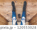 A girl in the boots with an iron mug of coffee on the terrace of a wooden house. concept 120553028