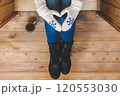 A girl in the boots with an iron mug of coffee on the terrace of a wooden house. concept 120553030