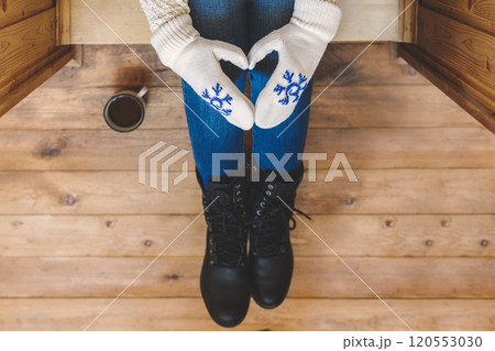 A girl in the boots with an iron mug of coffee on the terrace of a wooden house. concept A girl in the boots with an iron mug of coffee on the terrace of a wooden house. concept 120553030