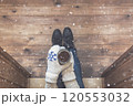 A girl in the boots with an iron mug of coffee on the terrace of a wooden house. concept 120553032