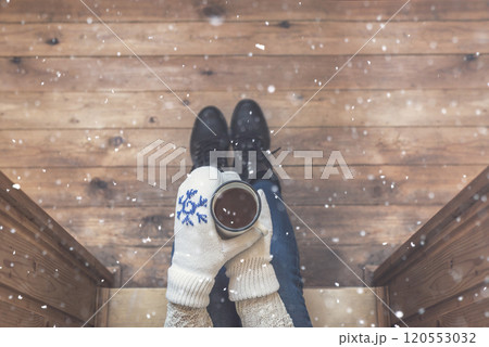 A girl in the boots with an iron mug of coffee on the terrace of a wooden house. concept A girl in the boots with an iron mug of coffee on the terrace of a wooden house. concept 120553032