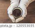 female hands  with an iron mug of coffee on the terrace of a wooden house. concept 120553035