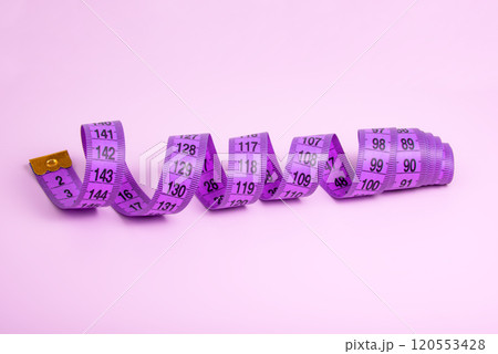 Bright purple tape measure on violet background with copyspace Bright purple tape measure on violet background with copyspace 120553428