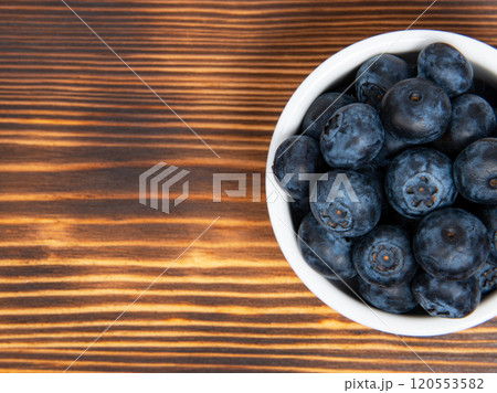 Fresh blueberry in white dish on wooden background 120553582