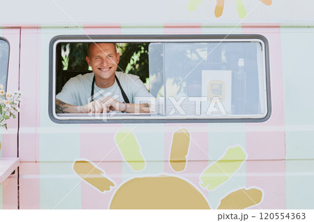 Portrait of Smiling Caucasian chef sitting in food truck while posing for photo 120554363