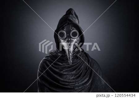 Plague doctor in hooded cloak at night over dark misty background Plague doctor in hooded cloak at night over dark misty background 120554434