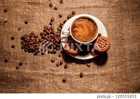 Coffee beans and a cup of coffee.cup of coffee and beans on dark background, top view Coffee beans and a cup of coffee.cup of coffee and beans on dark background, top view 120555853