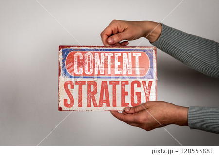 Content Strategy. Metal sign with the text in the hands of a woman on a white background 120555881