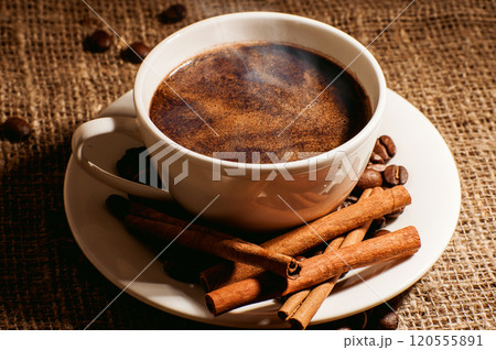 Coffee beans and a cup of coffee.Cup glass of coffee with smoke and coffee beans on old wooden backgroundth smoke and coffee beans on old wooden background Coffee beans and a cup of coffee.Cup glass of coffee with smoke and coffee beans on old wooden backgroundth smoke and coffee beans on old wooden background 120555891