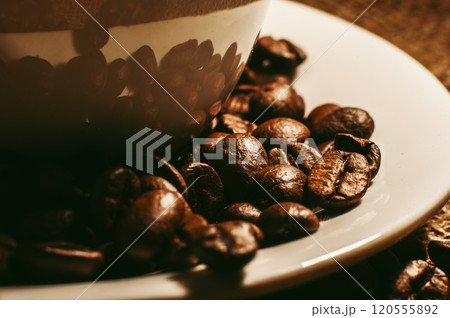 Coffee beans and a cup of coffee.Cup glass of coffee with smoke and coffee beans on old wooden backgroundth smoke and coffee beans on old wooden background Coffee beans and a cup of coffee.Cup glass of coffee with smoke and coffee beans on old wooden backgroundth smoke and coffee beans on old wooden background 120555892