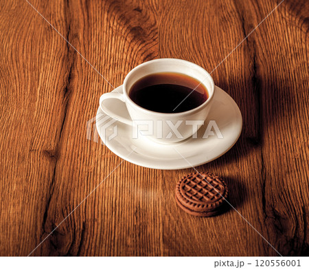 Cup glass of coffee with smoke and coffee beans on old wooden background.Delicious chocolate chip cookies with a cup of coffee 120556001