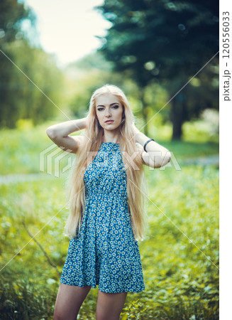 Beauty blonde with long and shiny long hair. The woman is stylish in a blue dress. Fashion. 120556033