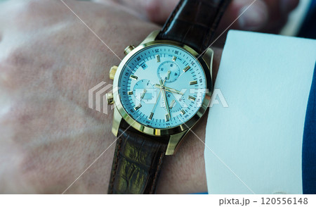 Businessman pointing at hand watch Businessman pointing at hand watch 120556148