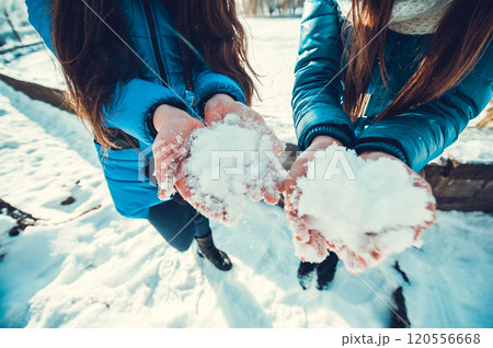 A group of little boys and girls in colorful clothes play outdoors during snowfall. Active vacation with children in winter on cold days. Happy siblings and twins having fun with snow A group of little boys and girls in colorful clothes play outdoors during snowfall. Active vacation with children in winter on cold days. Happy siblings and twins having fun with snow 120556668