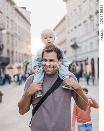 Portrait of smiling father carrying his toddler child piggyback around city on family vacations. Happy father's day 120556935